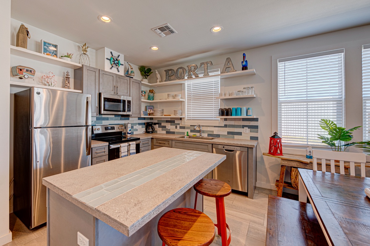 Cook up coastal memories in your fully-equipped kitchen featuring modern appliances, island seating, and charming nautical touches.