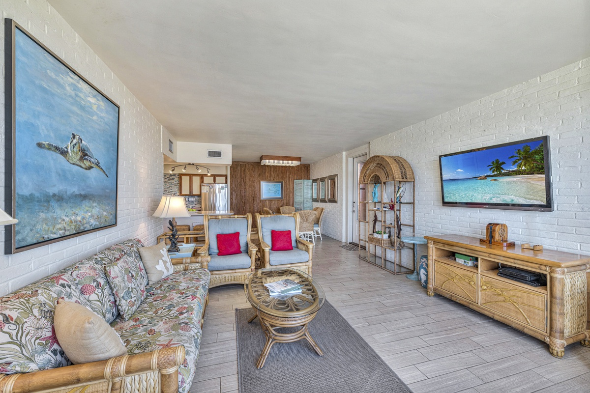 Unwind in your tropical-themed living space with ocean artwork and bamboo furnishings creating a serene island atmosphere.