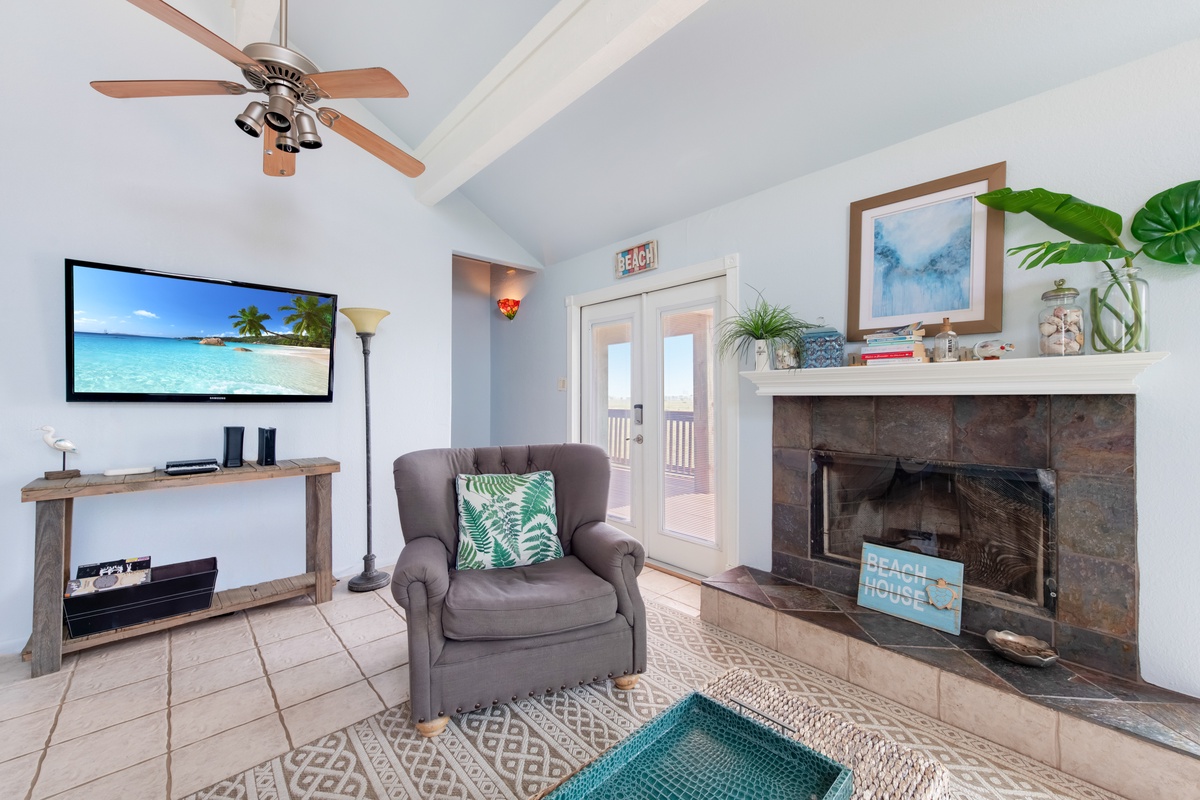 Unwind in your bright living room with tropical touches, where the cozy fireplace and ceiling fan create perfect comfort year-round.