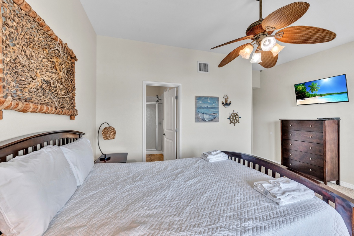 Drift off in your coastal-themed bedroom with tropical ceiling fan, nautical décor, and crisp linens for the perfect beach retreat.