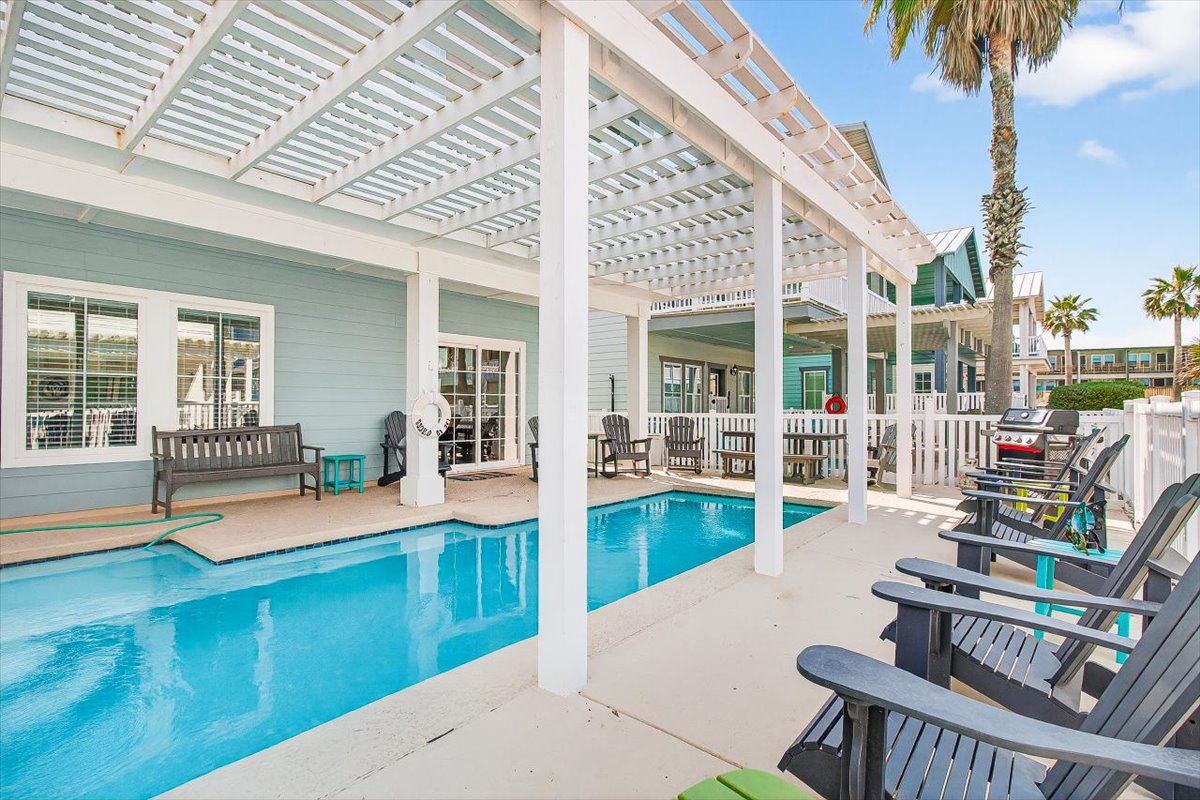 Relax poolside under your private pergola, where turquoise waters meet coastal comfort in this tropical retreat.