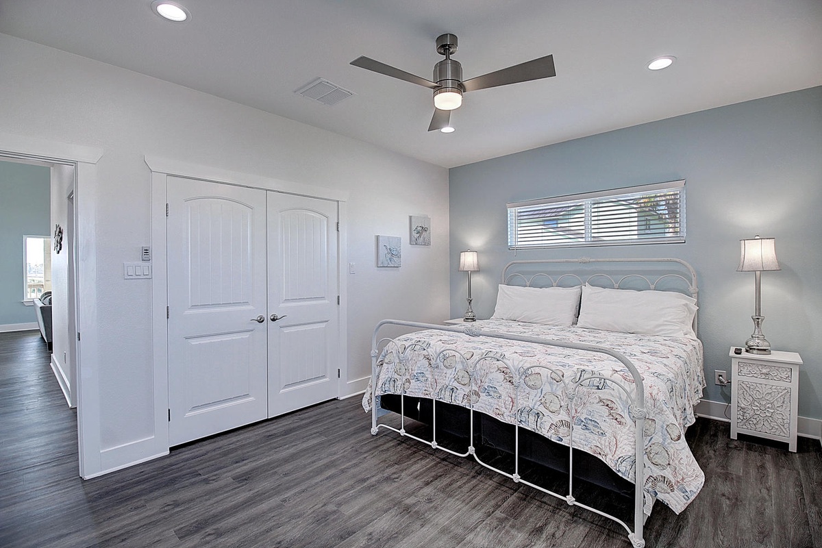 Unwind in your serene bedroom featuring soft linens, gentle ceiling fan breezes, and calming coastal tones for restful nights.