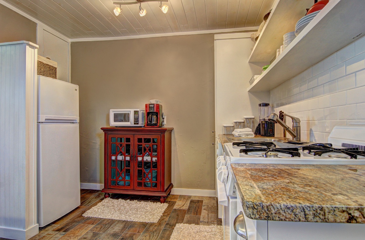 Your fully equipped kitchen features granite counters, gas stove, and charming farmhouse details for memorable meal preparation.