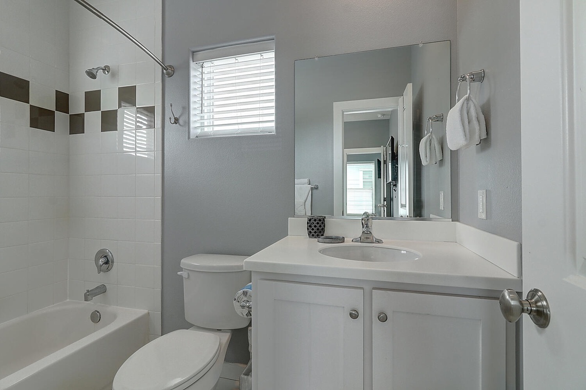Your private bathroom features a relaxing tub-shower combo with designer tile accents and fresh towels awaiting your arrival.