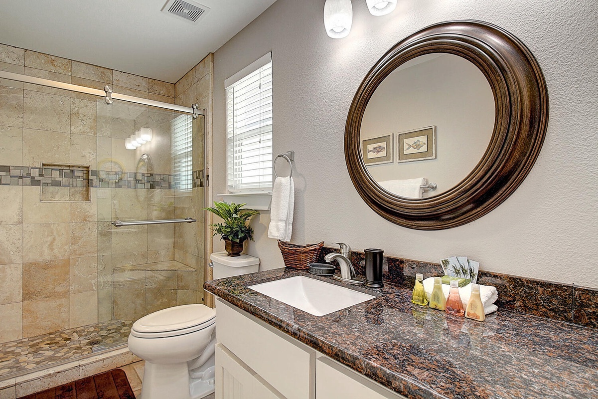Luxurious bathroom features elegant stone shower, granite counters, and thoughtful amenities for your perfect retreat.