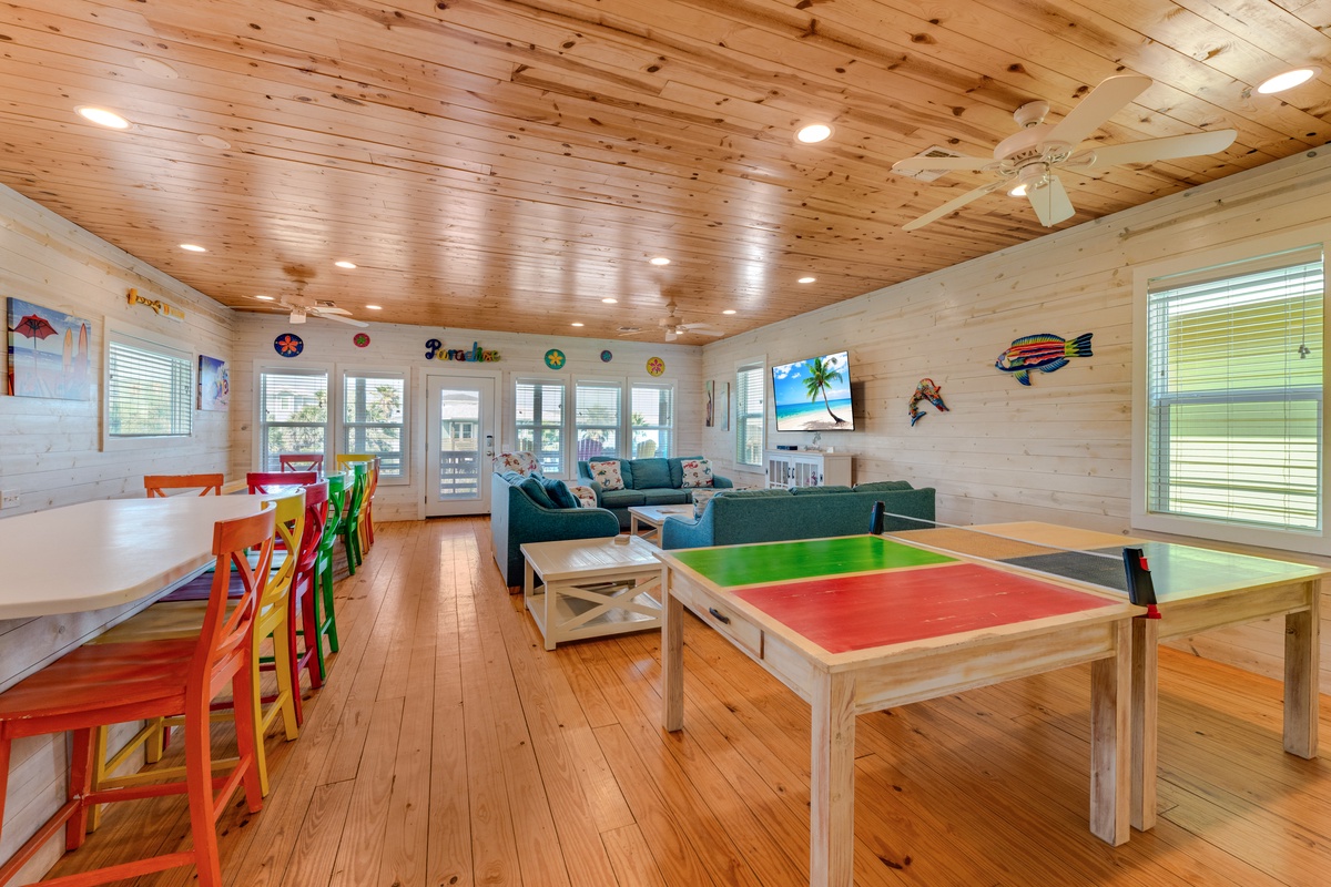 Your family's perfect retreat features a game table, cozy seating, and dining space—all under beautiful wood ceilings.