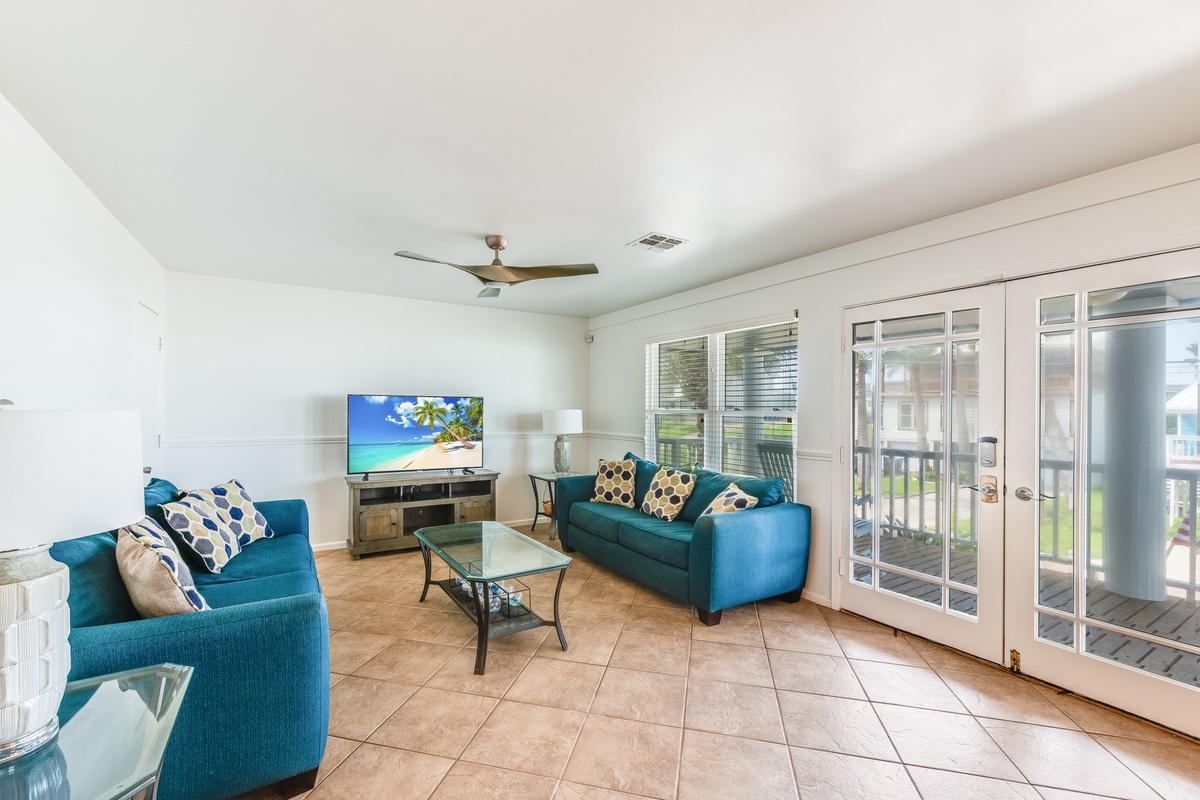 Unwind in your bright living room with comfortable teal seating and French doors opening to your private outdoor space.
