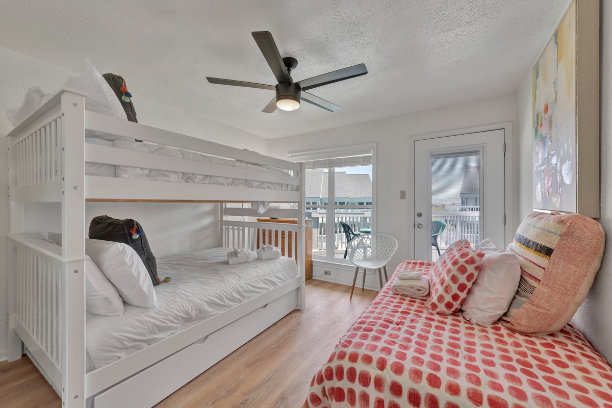 Cozy bedroom with bunk bed and balcony access—perfect for families seeking comfort and outdoor relaxation together.