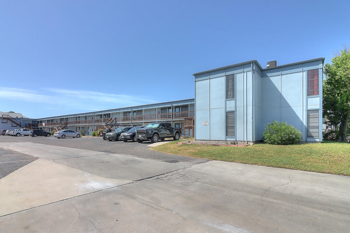 Modern property building with convenient parking and well-maintained grounds creates a welcoming arrival experience.