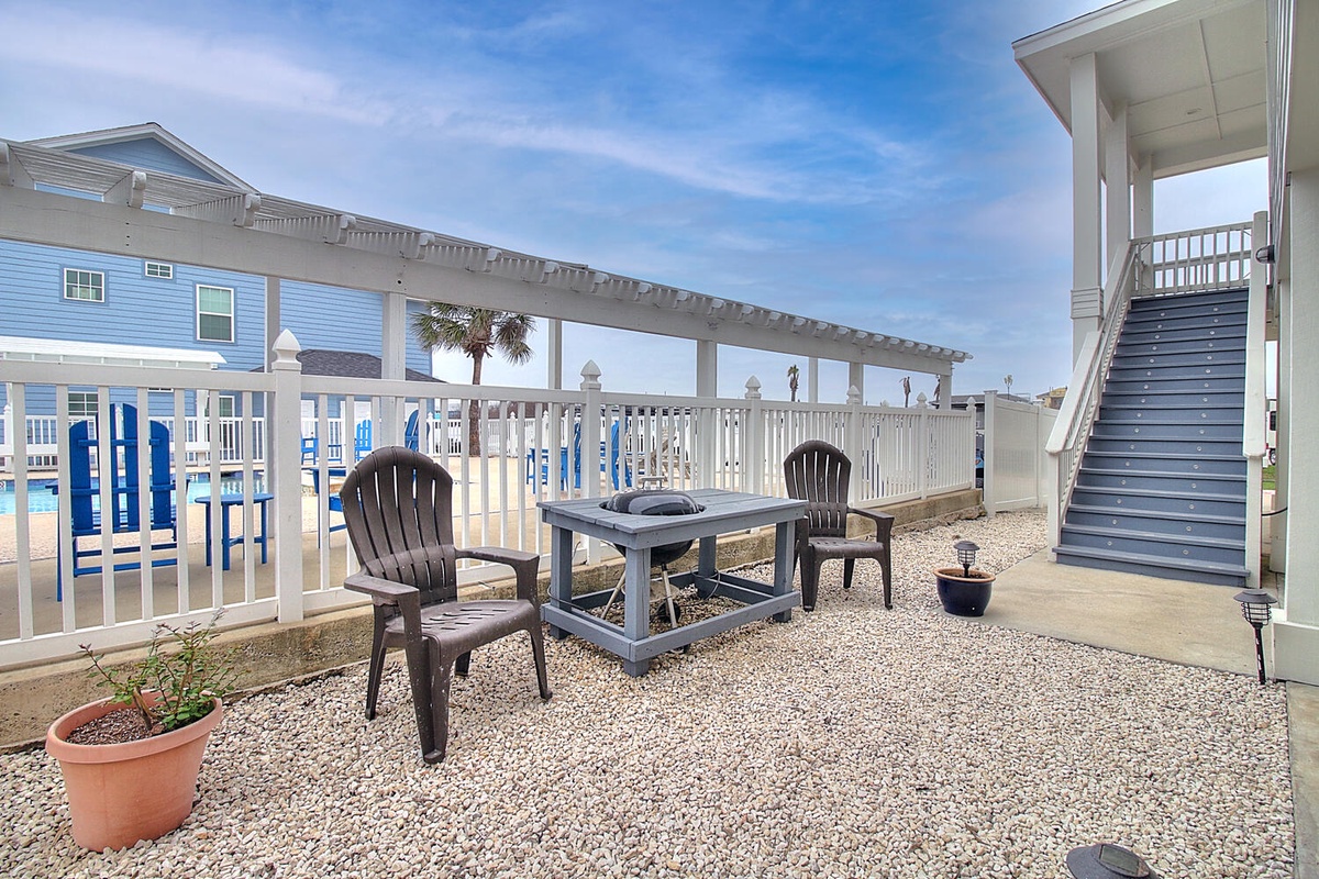 Relax on your private patio with cozy seating and fire pit, perfect for evening conversations under coastal skies.