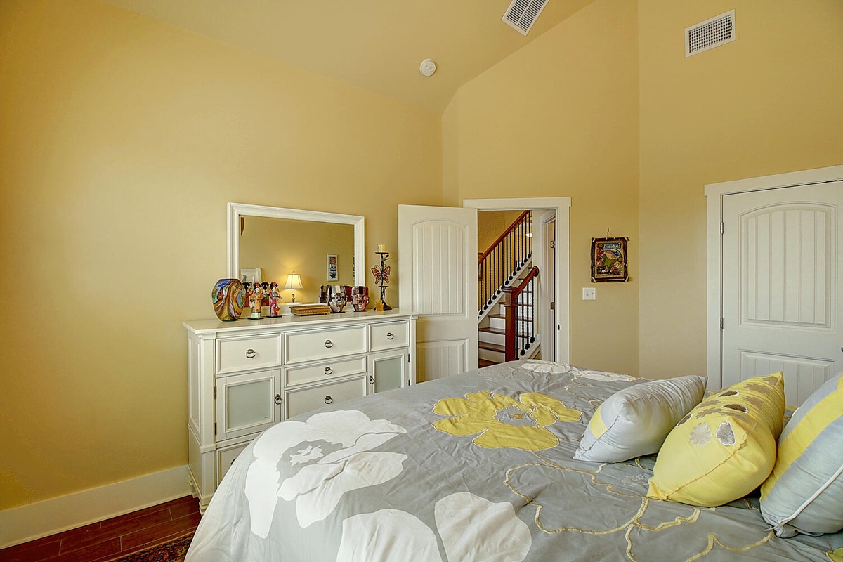 Rest peacefully in this bright bedroom featuring cheerful yellow accents and elegant white furniture that creates your perfect retreat.
