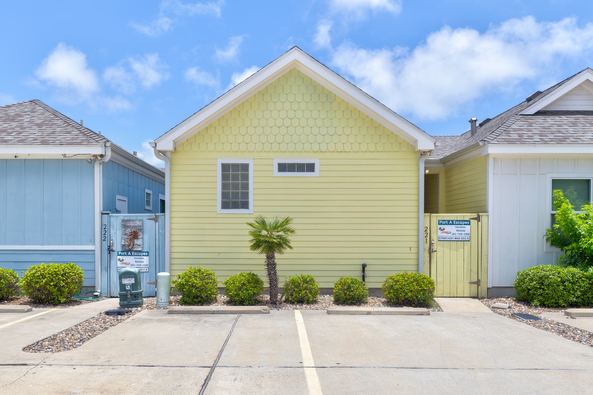 Charming coastal cottages with colorful siding and tropical landscaping create a welcoming beachside community atmosphere.