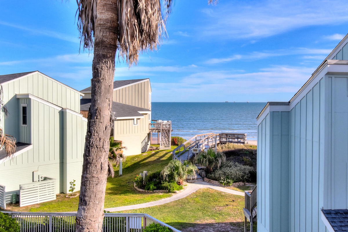Coastal community with beach access walkways and ocean views visible between charming seaside buildings.