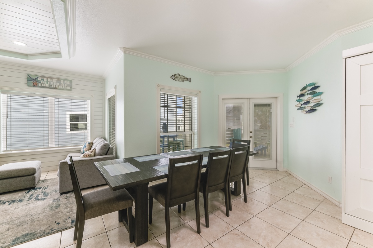 Your coastal dining space features fresh seafoam walls and sleek dark wood table perfect for memorable meals with loved ones.