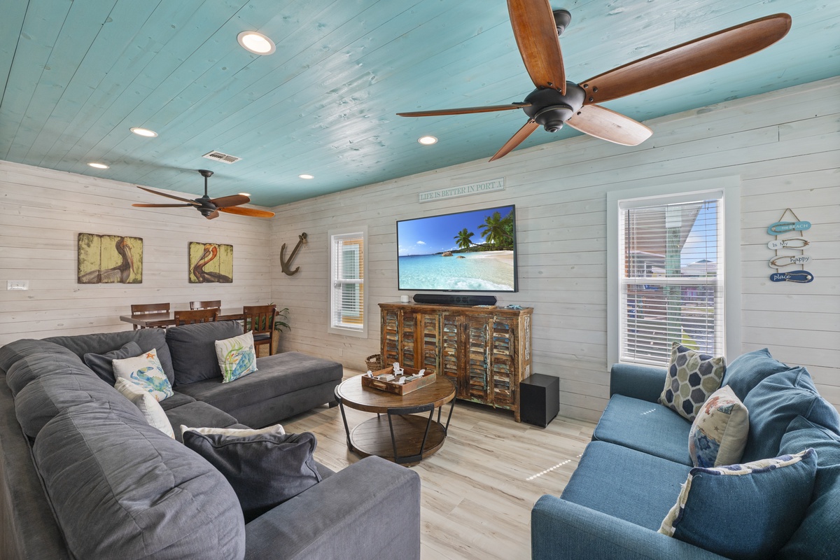 Sink into plush sofas and unwind in your coastal-inspired living space, where soothing turquoise ceilings and beachy décor set the scene for your perfect vacation.