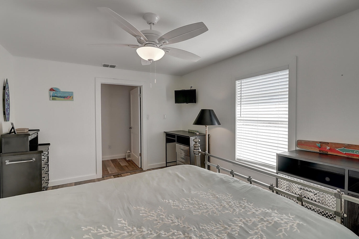 Relax in your comfortable bedroom with modern ceiling fan, wall-mounted TV, and plenty of natural light for the perfect getaway retreat.
