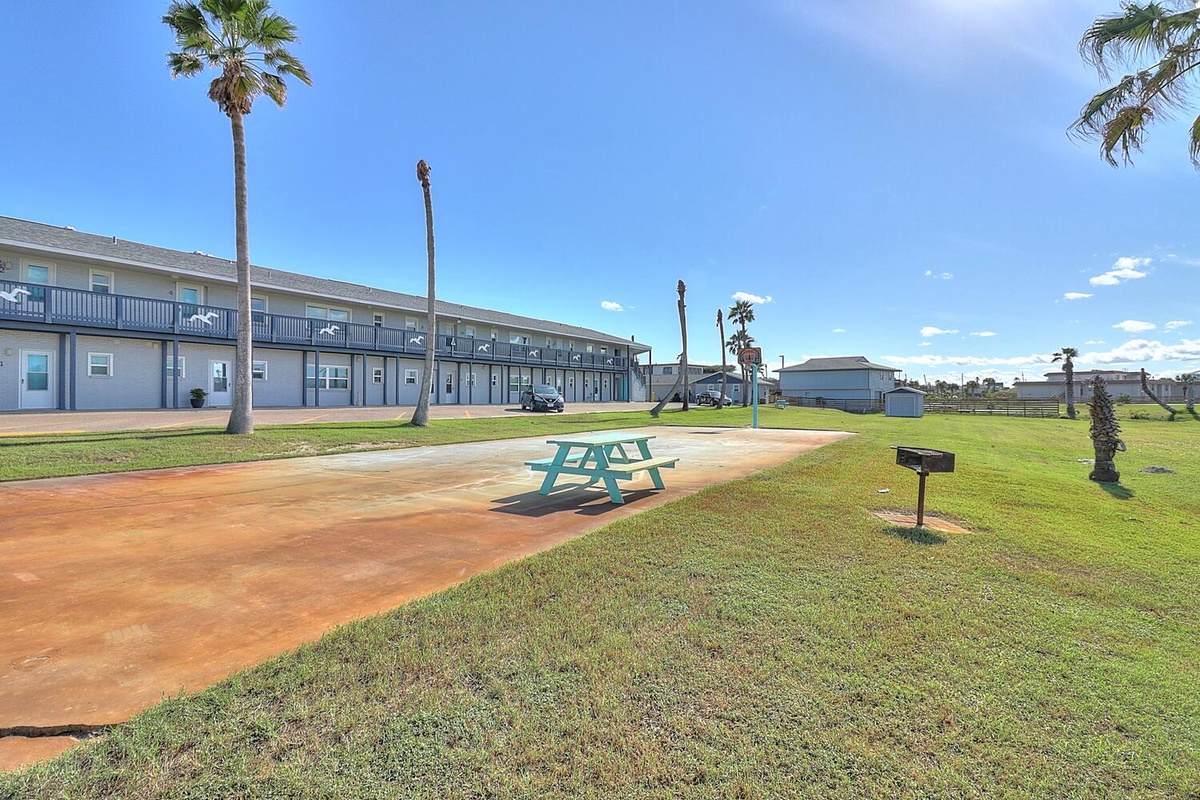 Property grounds feature picnic areas with palm trees and spacious outdoor spaces for relaxation under sunny coastal skies.