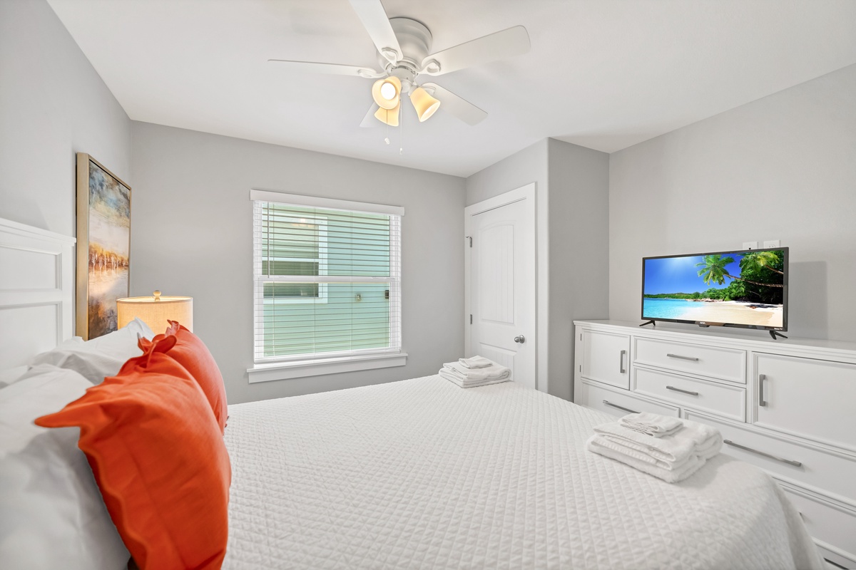 Relax in your peaceful bedroom with plush bedding, tropical views on TV, and fresh towels waiting for your arrival.