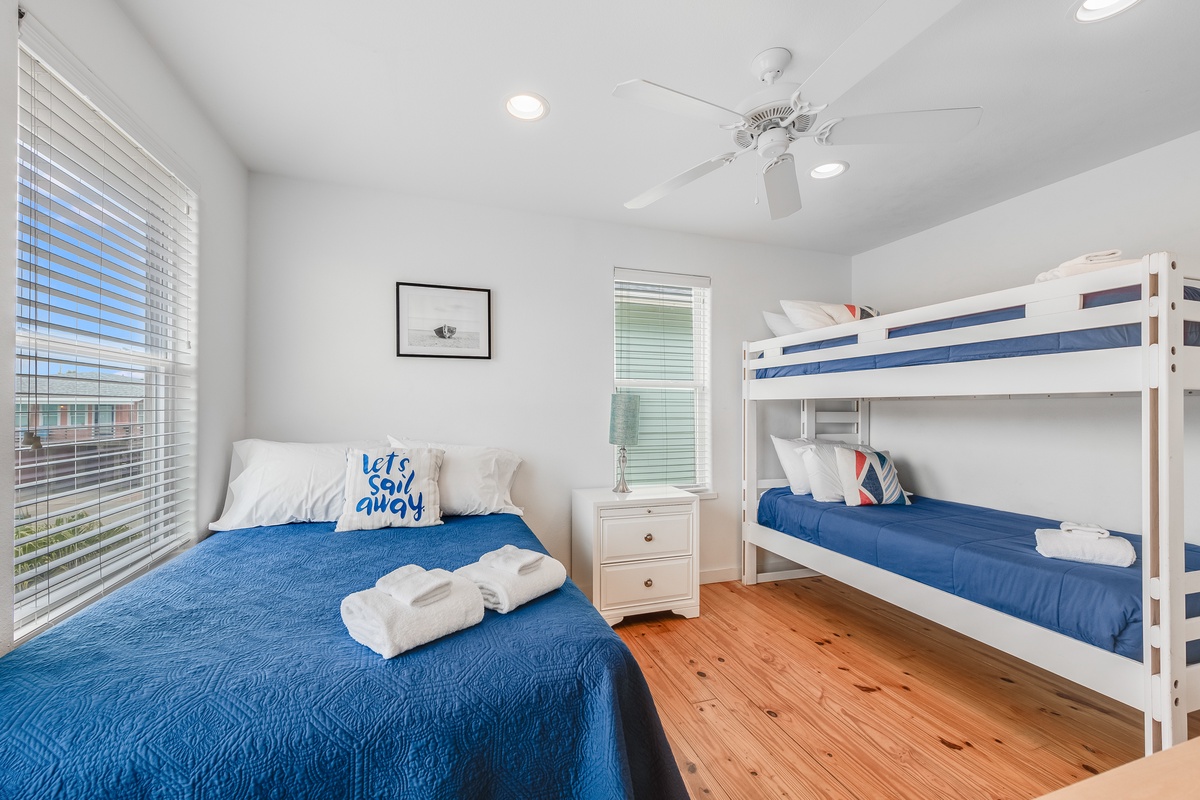Your coastal-themed bedroom features comfortable bedding, full bed and a playful bunk bed for kids, and warm wood floors that invite relaxation.