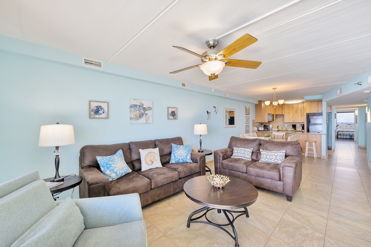 Sink into plush leather seating in your coastal-themed living room, where soft blues and beach artwork create a tranquil retreat.