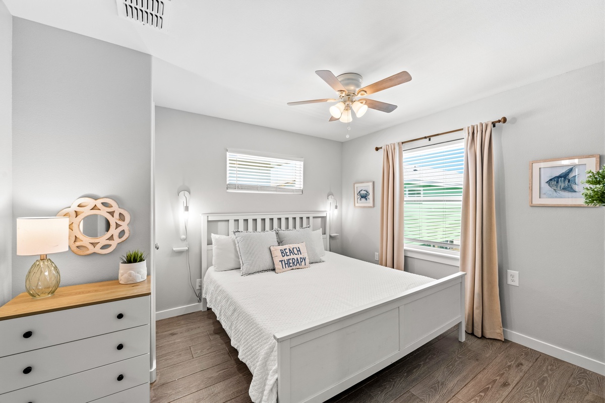 Your coastal-inspired retreat awaits with soft linens, gentle breezes from the ceiling fan, and natural light streaming through plantation shutters. Beach-themed touches remind you that relaxation is your only agenda.