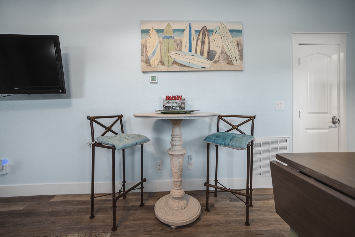 Enjoy casual meals at your charming bistro table with coastal artwork setting a relaxing seaside mood.