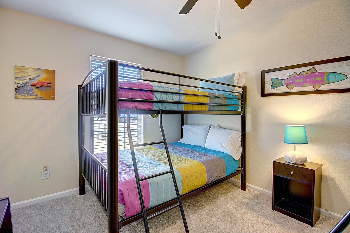 Your kids will love this colorful bunk bed room with bright bedding and fun fish artwork on the walls.