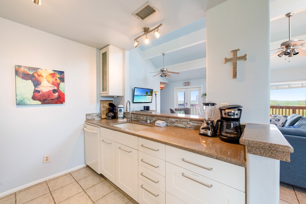 Your bright kitchen features granite counters, modern appliances, and a coffee maker ready for your morning brew.