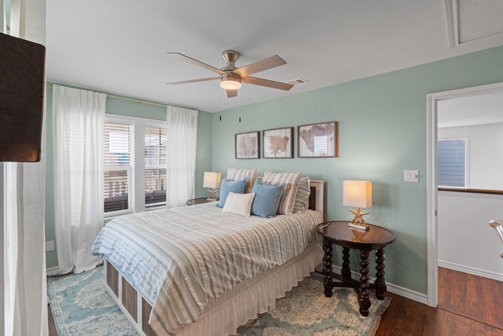 Drift off in this serene bedroom with soft mint walls, gentle ceiling fan, and dreamy coastal bedding that invites peaceful sleep.