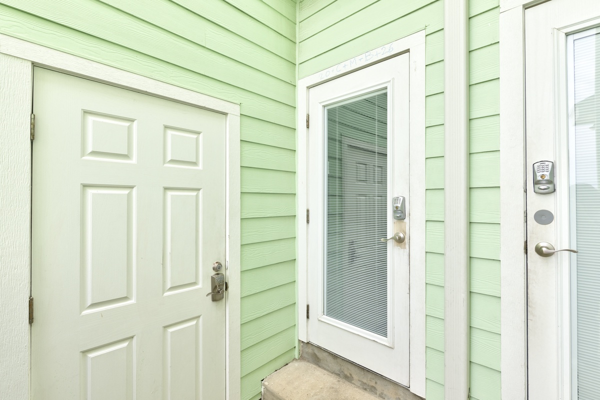 Charming green exterior welcomes guests with multiple entry points and modern keypad access for convenient arrival.