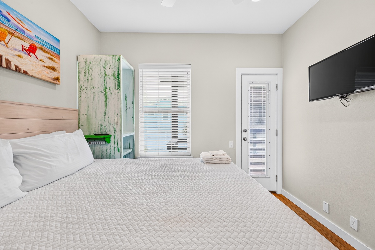 Unwind in your bright primary bedroom, featuring soft linens, natural light, and charming coastal touches.