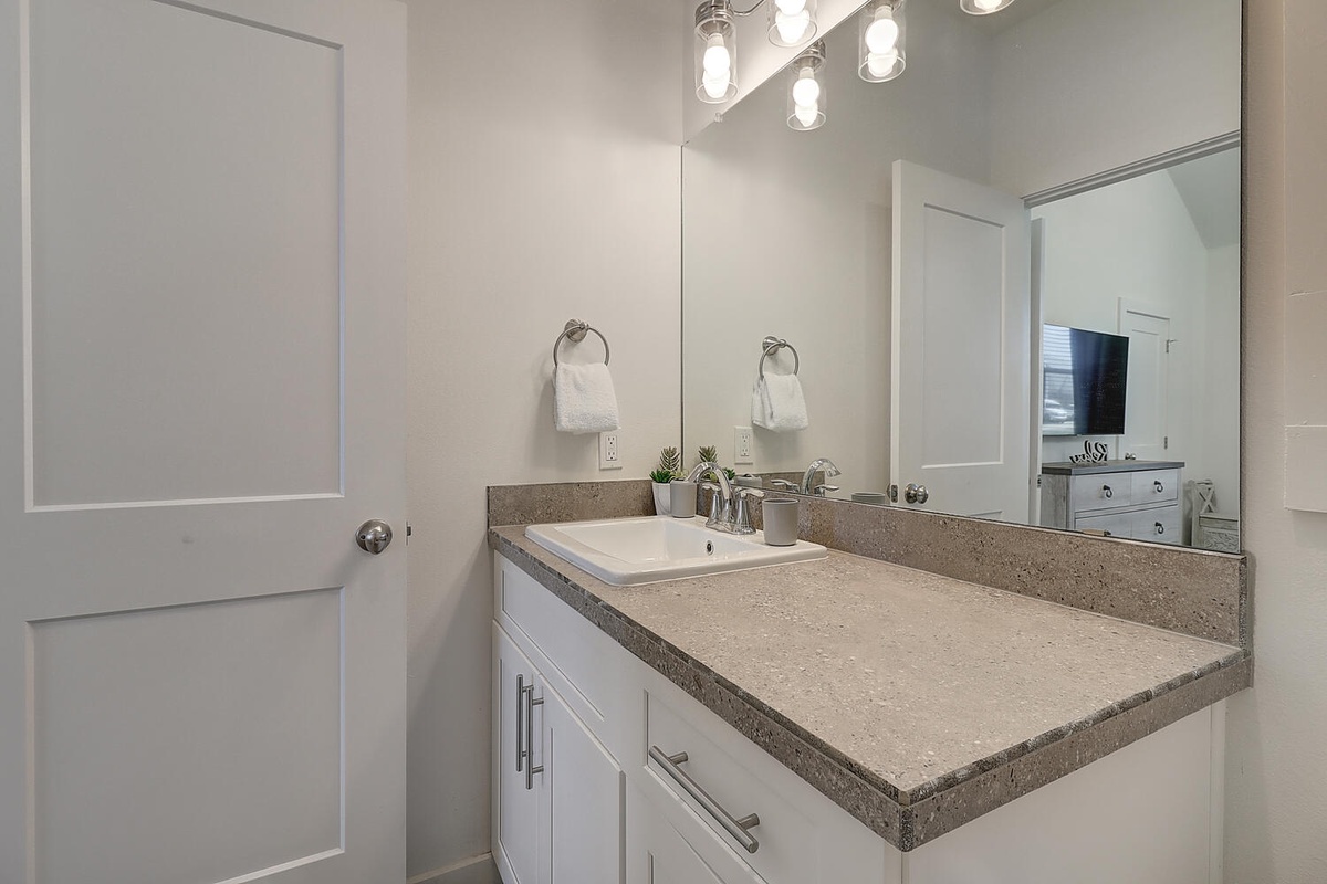Your modern bathroom features elegant granite countertops, crisp white cabinetry, and stylish vanity lighting perfect for your morning routine.