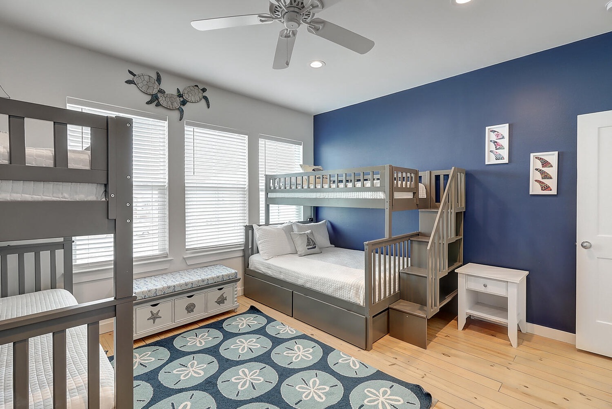 Your kids will love this ocean-themed bunk room with sea turtle art and a cozy reading nook by the window.
