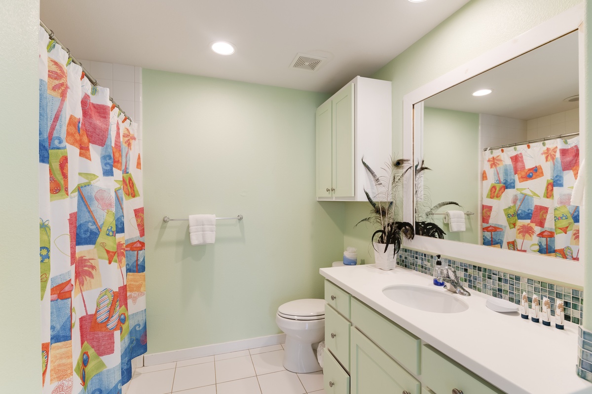 Refresh in your vibrant bathroom featuring colorful tropical decor, mosaic tile accents, and thoughtful amenities that make your daily routine feel like a mini getaway.