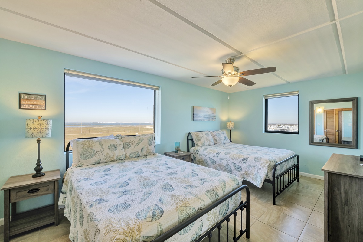 Drift off to sleep in your coastal bedroom with twin beds featuring ocean-themed linens and soothing sea-green walls.