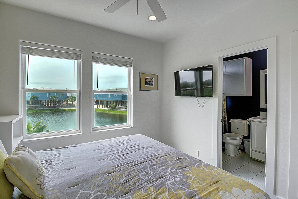Wake up to stunning waterfront views from your cozy bedroom, where morning light streams through windows overlooking peaceful canal waters.