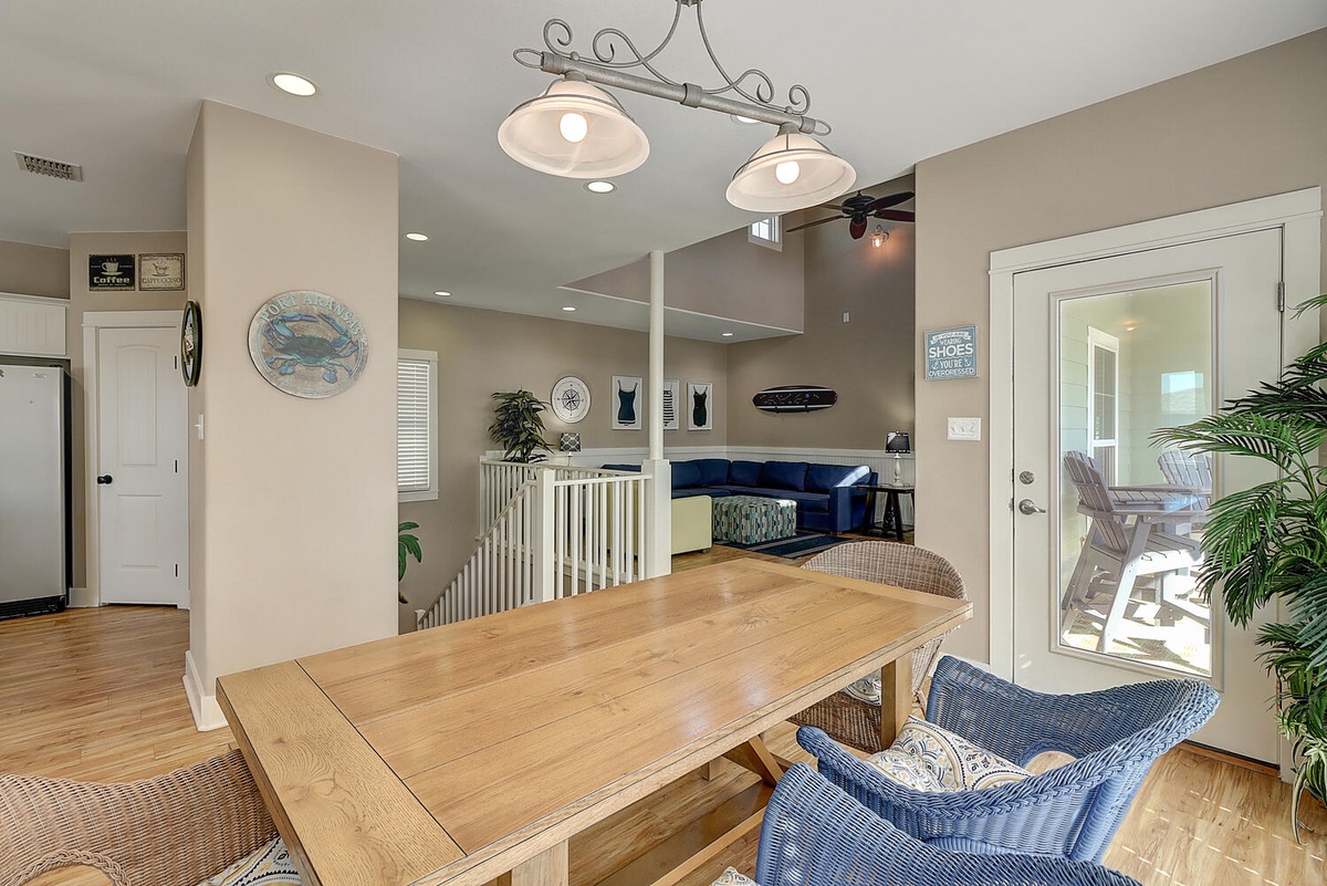 Your coastal-inspired dining space features a warm wood table perfect for family meals, with stylish nautical touches throughout.