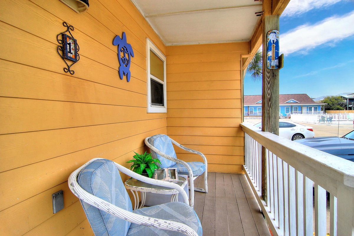 Relax in your private wicker chairs on this sunny balcony, where colorful coastal touches create your perfect morning coffee spot.