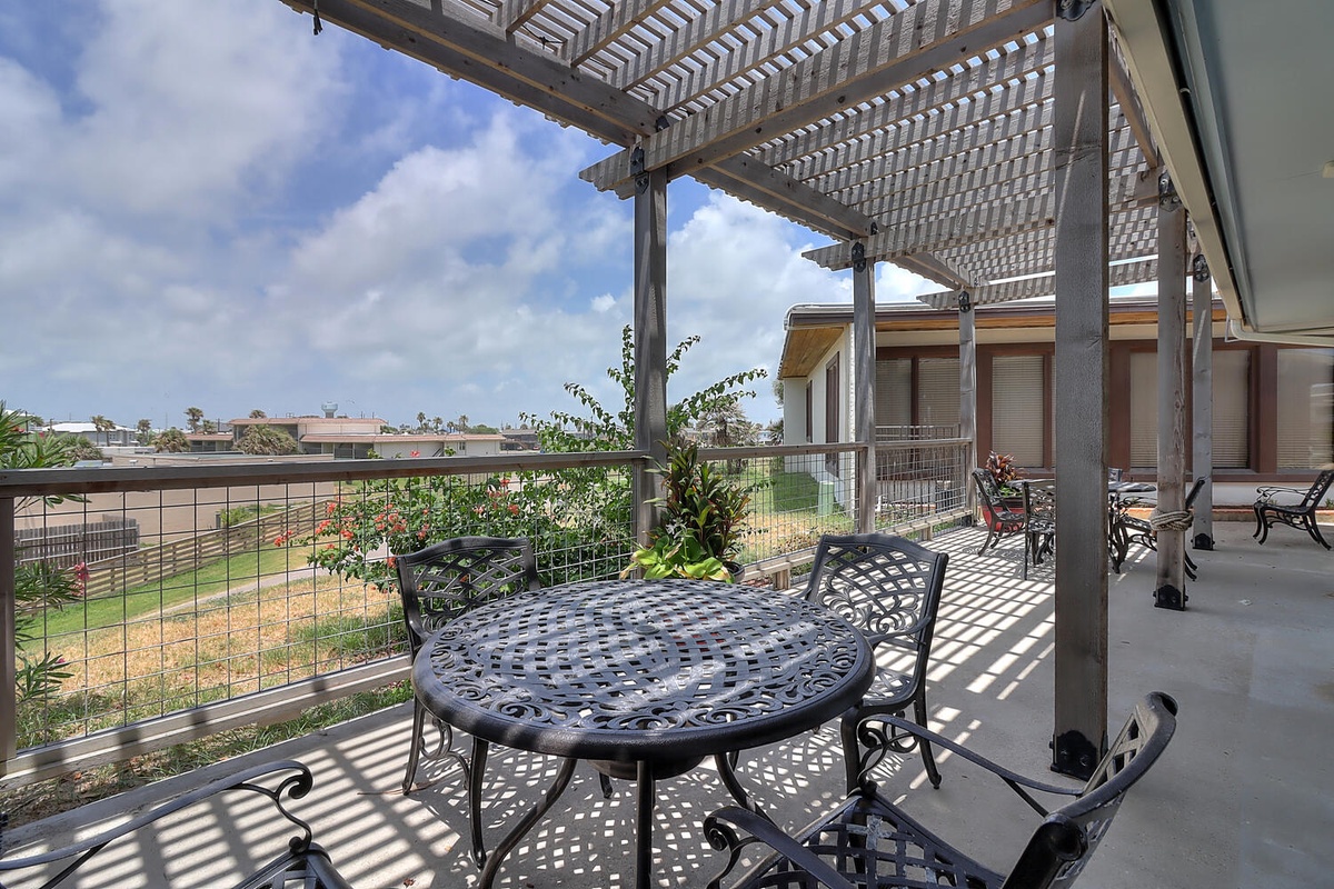 Your private terrace offers peaceful dining under a pergola, with garden views and dappled sunlight creating the perfect spot for morning coffee or evening meals.