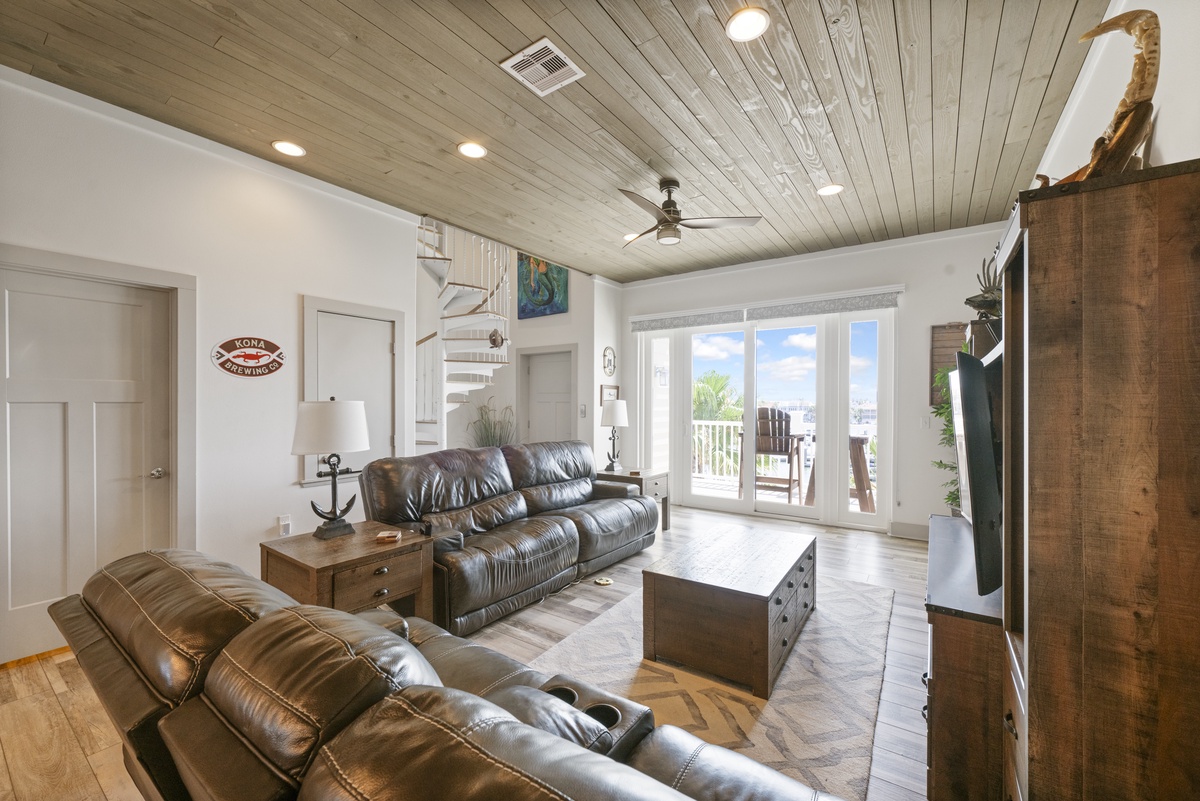 Sink into plush leather seating beneath rustic wood ceilings, where nautical touches and natural light create your perfect coastal retreat.