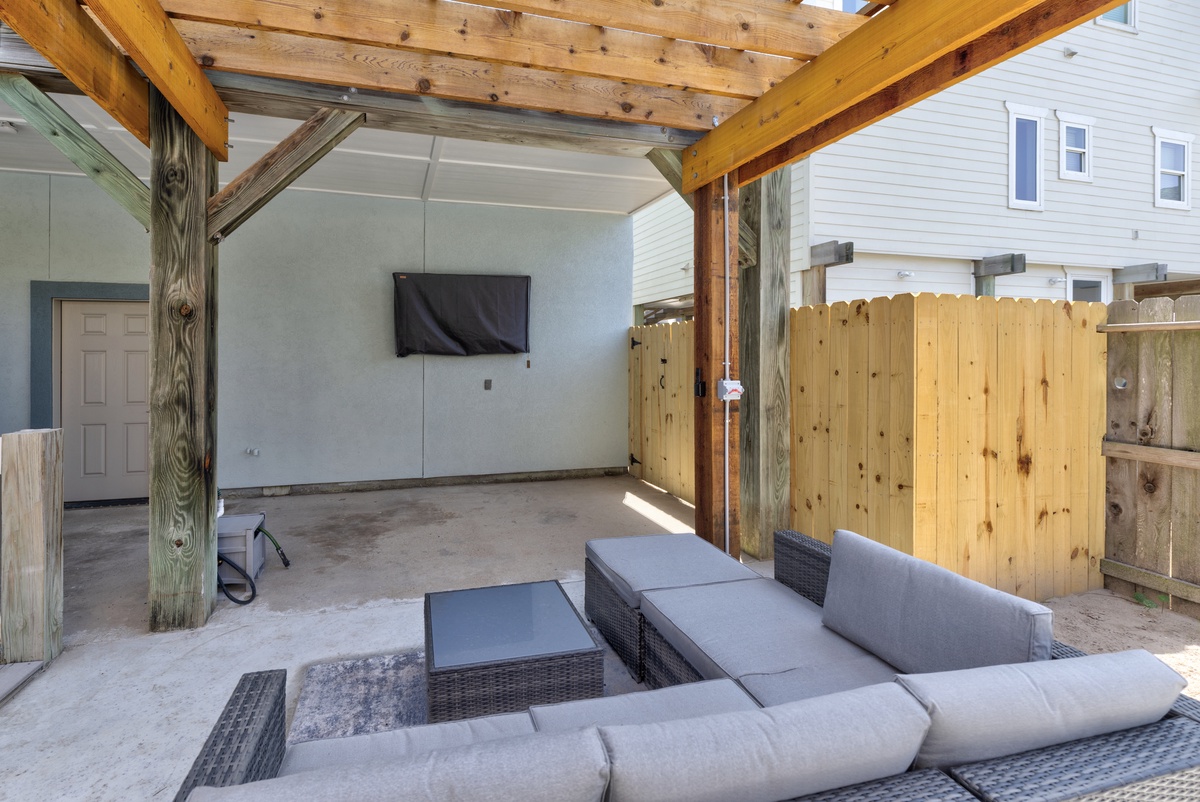 Unwind in your private covered patio with comfortable seating and entertainment, perfect for relaxing after exploring the area.