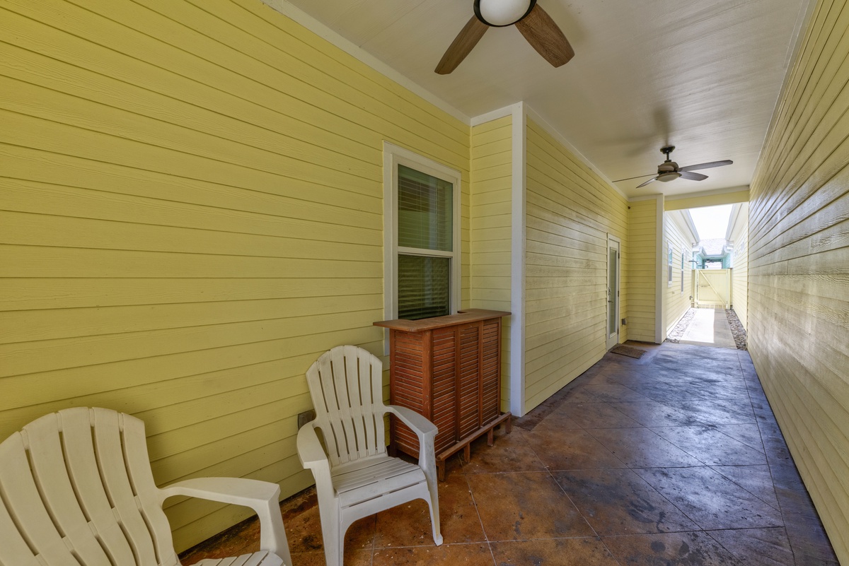 Settle into your private covered porch with Adirondack chairs, perfect for morning coffee or evening relaxation in this charming coastal retreat.