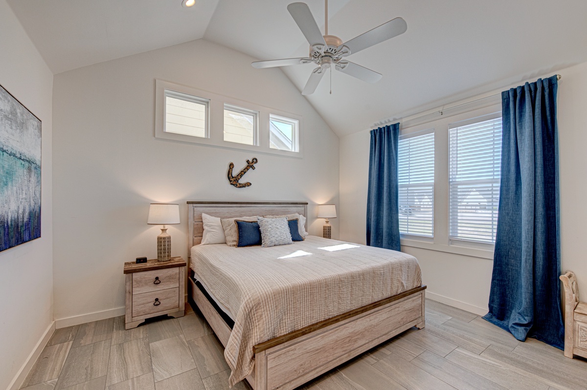Sleep peacefully in your coastal-inspired bedroom with vaulted ceilings, soothing nautical touches, and gentle ocean breezes from the ceiling fan.