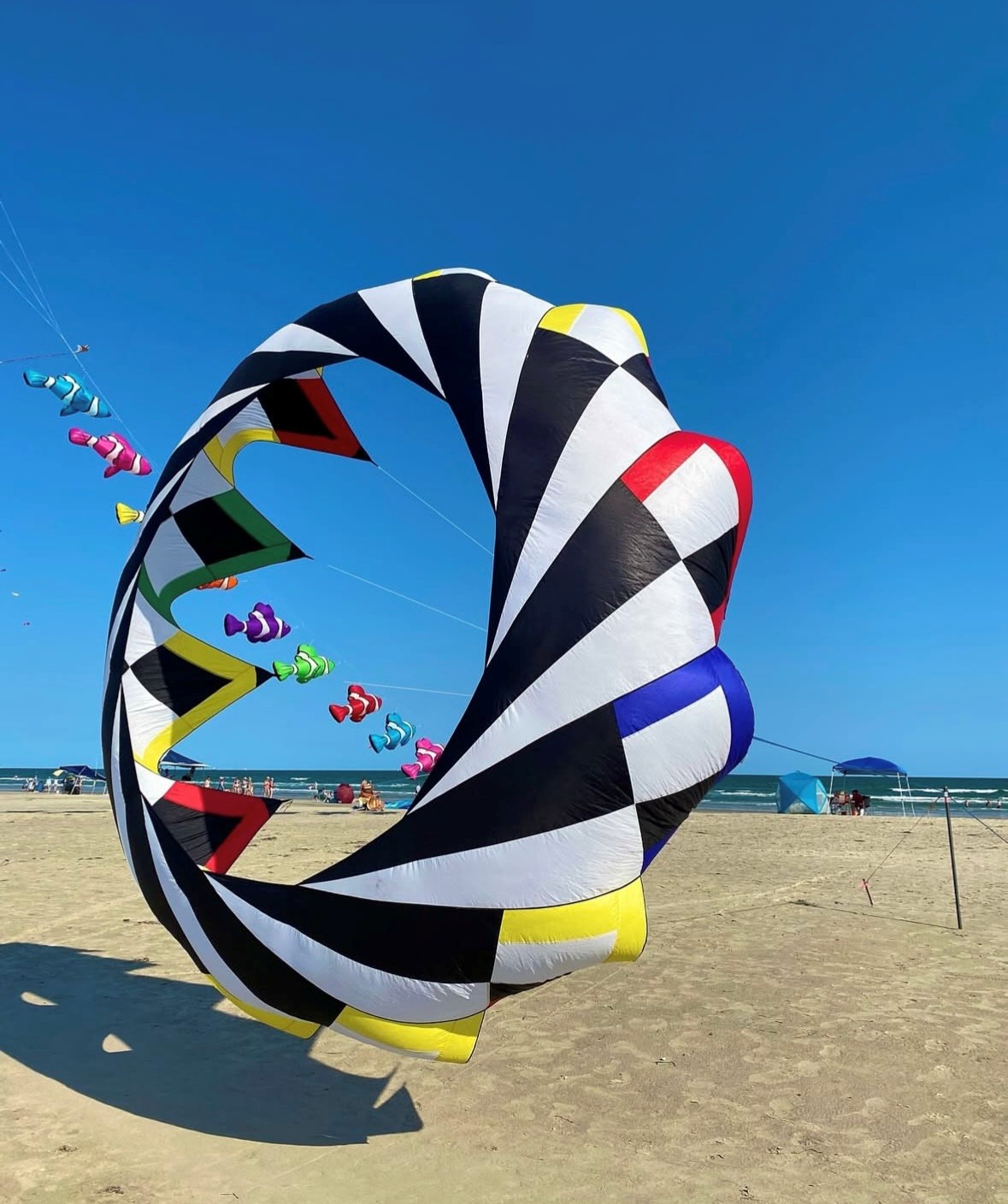 A vibrant kite festival transforms the nearby beach into a spectacular display of colorful shapes dancing against the brilliant blue sky.