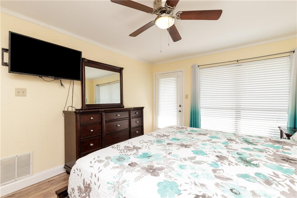 Unwind in your peaceful bedroom with a comfortable bed, entertainment center, and ceiling fan for perfect temperature control.