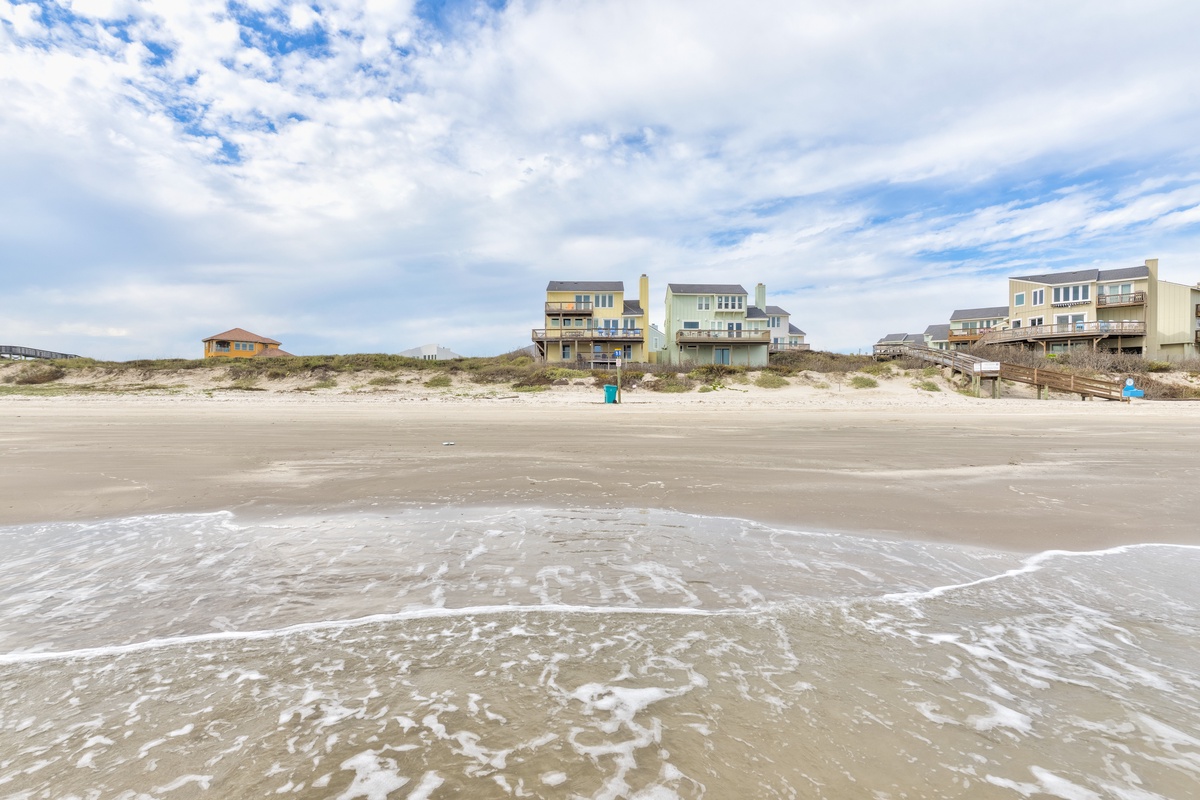 Oceanfront rental properties line this pristine stretch of beach with direct sand access and stunning coastal views.