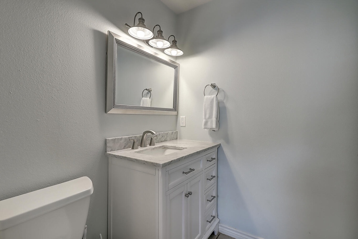 Freshen up in your stylish bathroom with marble countertop, elegant lighting, and plush towels awaiting your arrival.