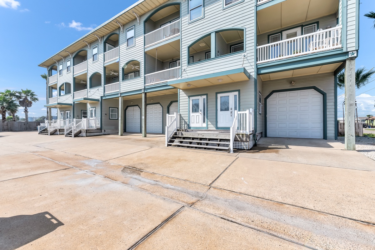 Modern coastal building with convenient parking and private balconies in a tropical setting.