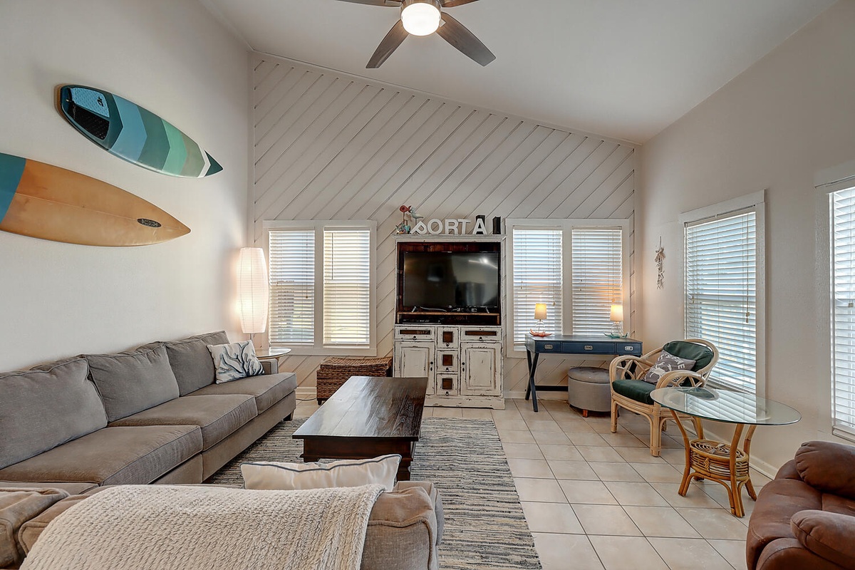 Unwind in your surf-inspired living room with comfy sectional seating, coastal décor, and entertainment center for perfect beach house vibes.