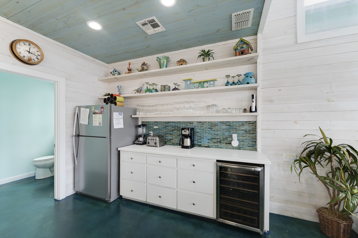 Your charming coastal kitchen features modern appliances, ocean-inspired décor, and open shelving perfect for preparing memorable vacation meals together.
